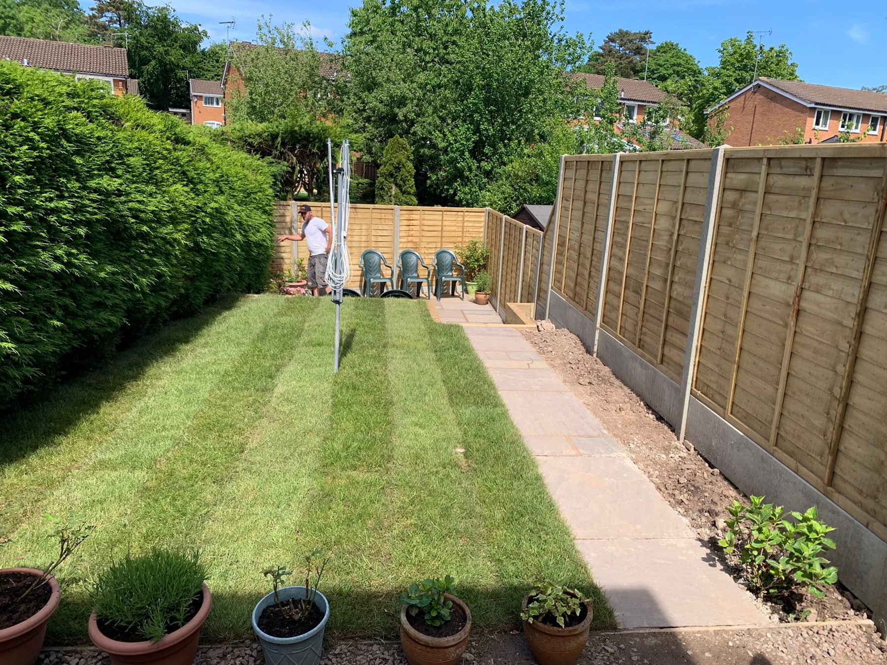 Newly laid lawn and sandstone path along a fresh fence line
